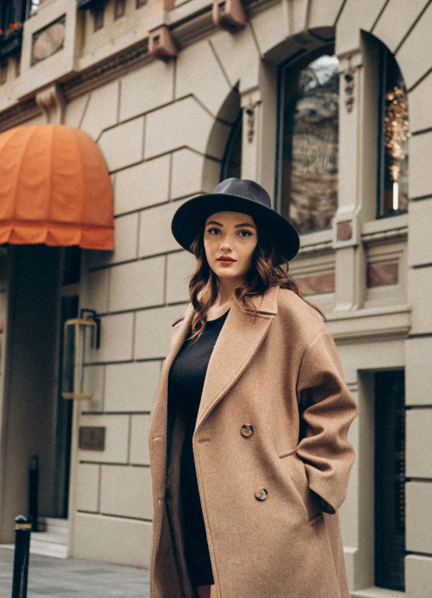 Woman in oversized camel coat walking in city street